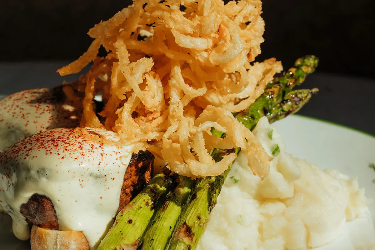 Plated steak with fried onions, asparagus and mashed potatoes