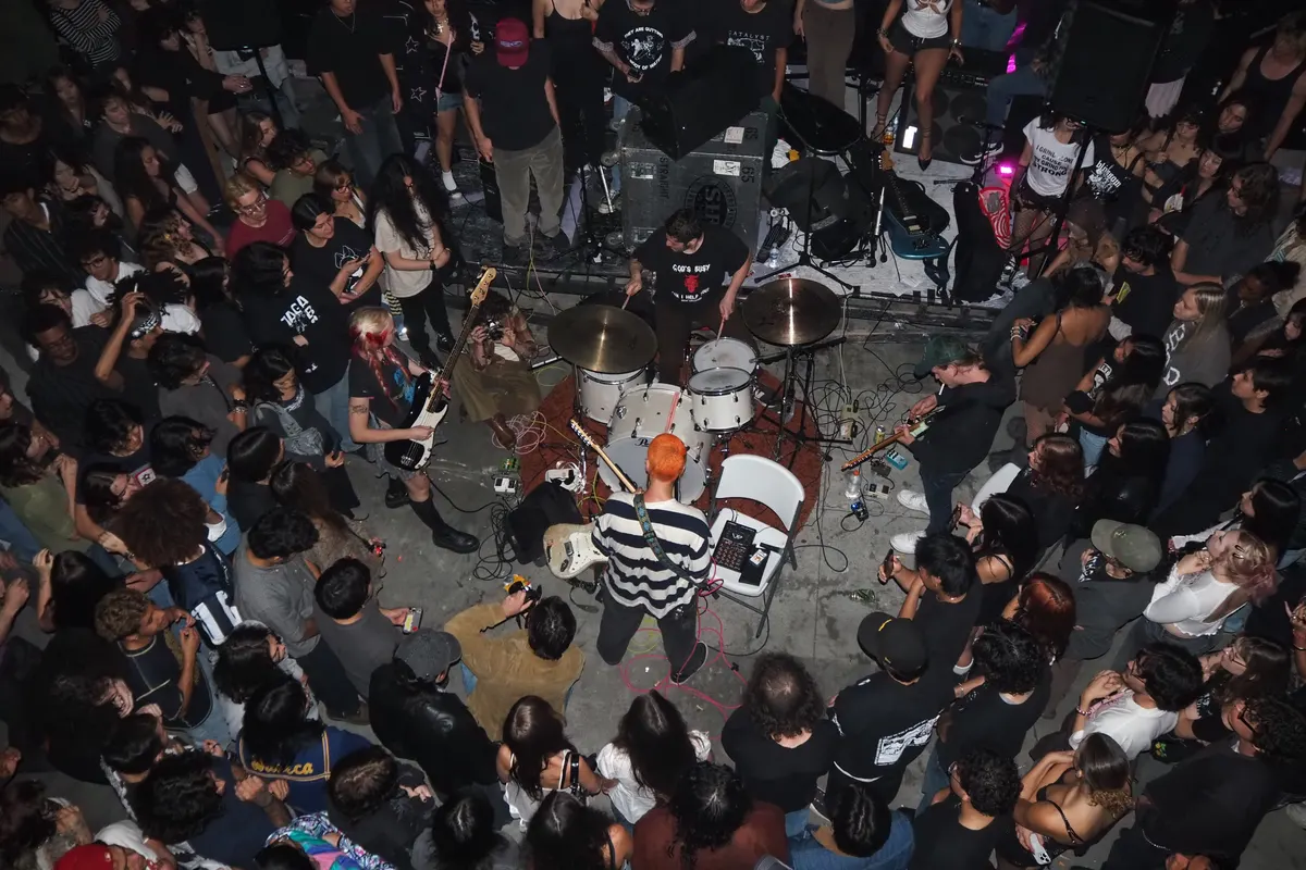 Packed crowd circling a band playing on the floor at a club show
