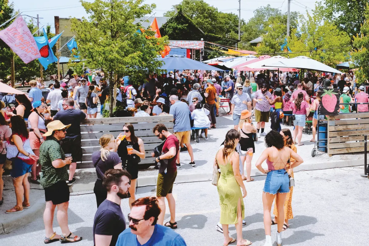Crowd gathered outdoors in the Land-Grant beer garden on a sunny day