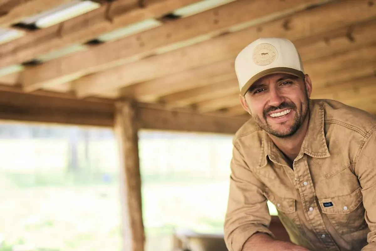 Smiling man in a cap and tan work shirt