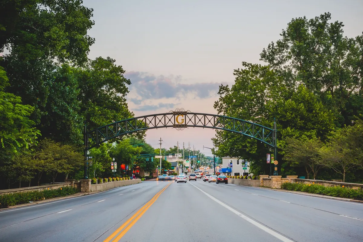 Green arch over a tree-lined Gahanna street at dusk