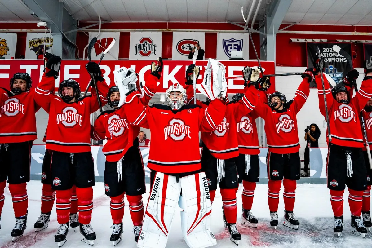 Ohio State hockey players raise sticks and arms on the ice