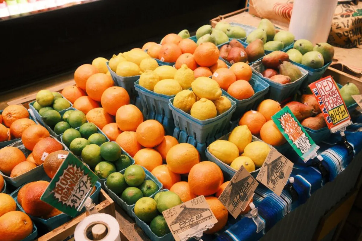 Crates of oranges, lemons, limes and pears on a market stall