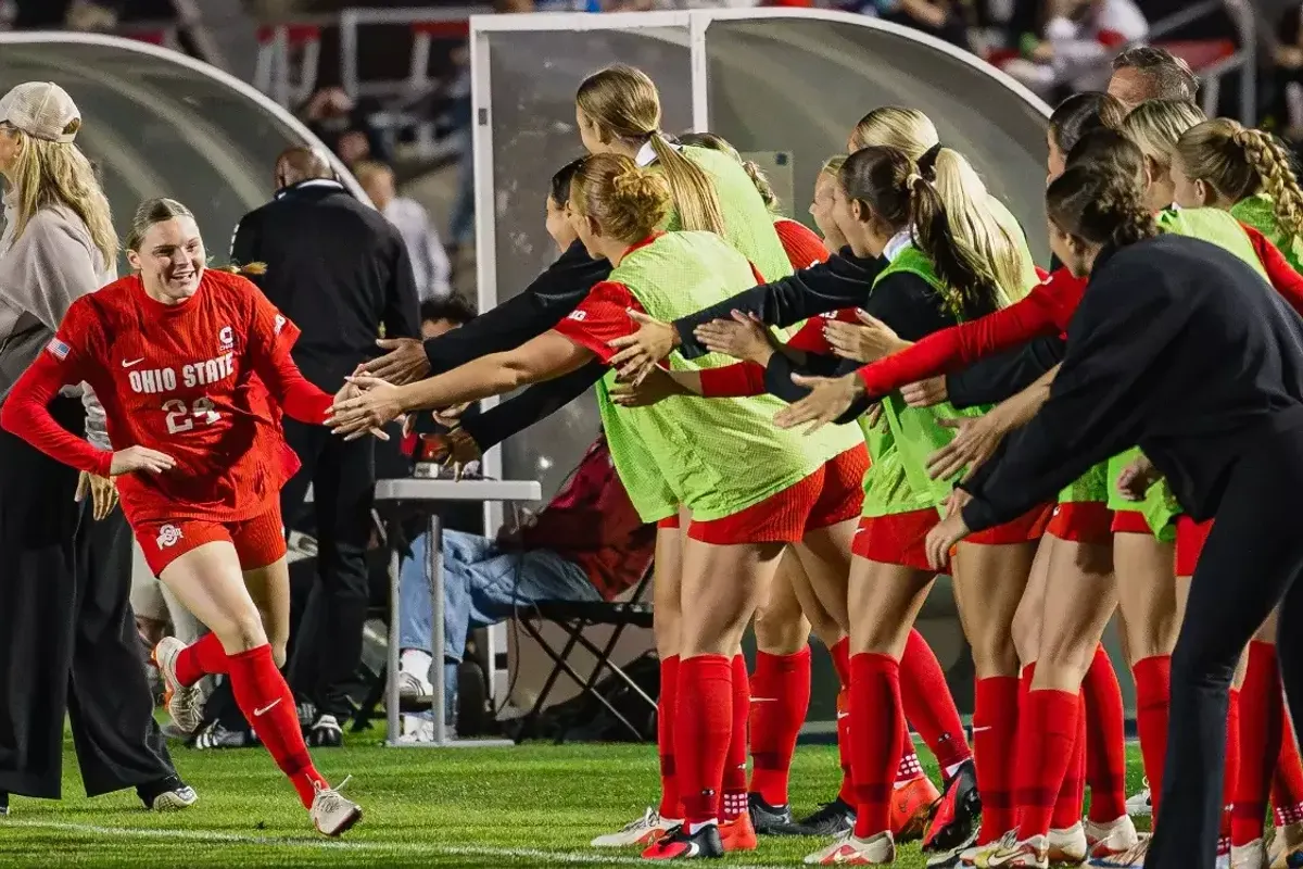Ohio State women's soccer player high-fives teammates along the sideline