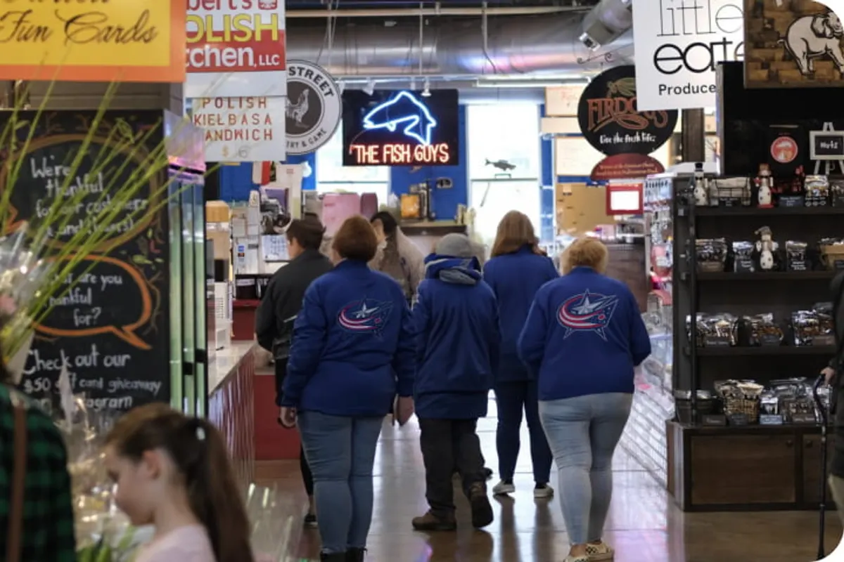 Shoppers walking through North Market aisle past food stalls